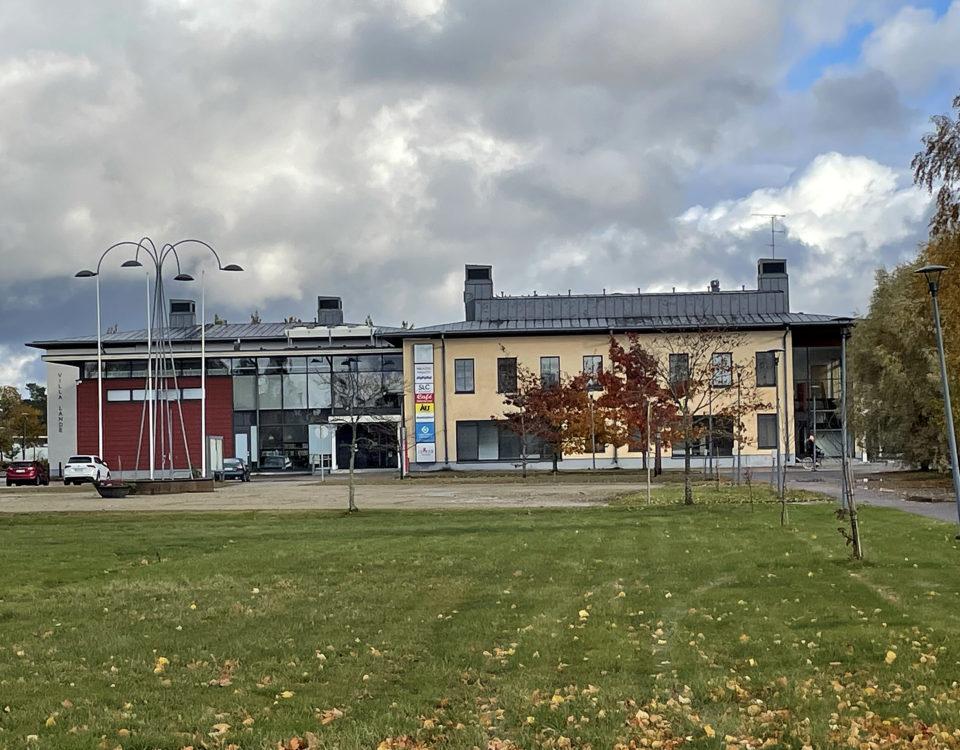 kulturhus på andra sidan en gräsmatta och ett torg