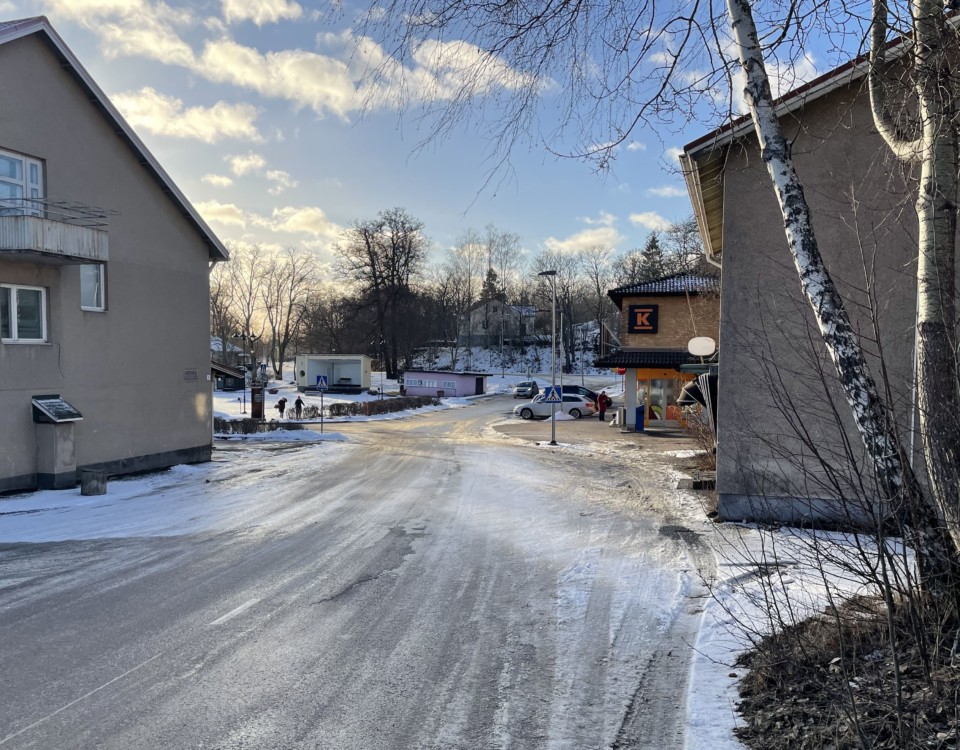 Gata som går mellan två hus förbi ett torg längre fram