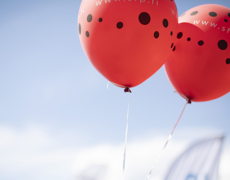 röda ballonger med svarta prickar mot blå himmel