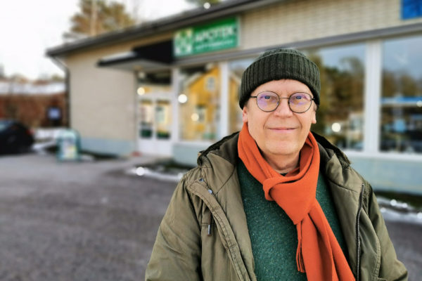 man framför hus på vintern