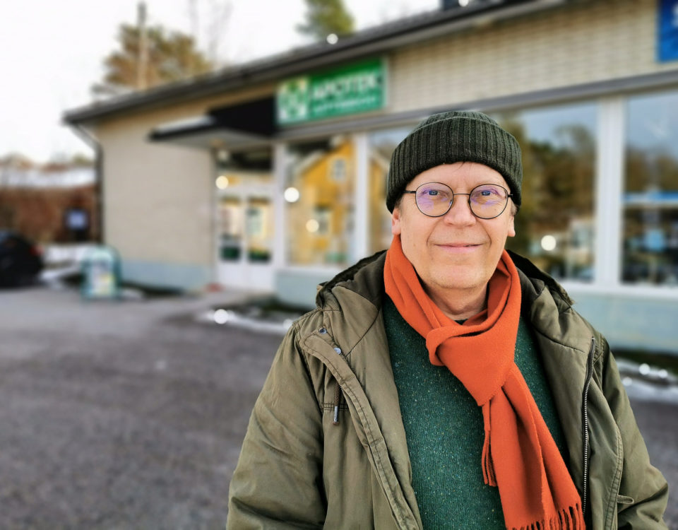 man framför hus på vintern