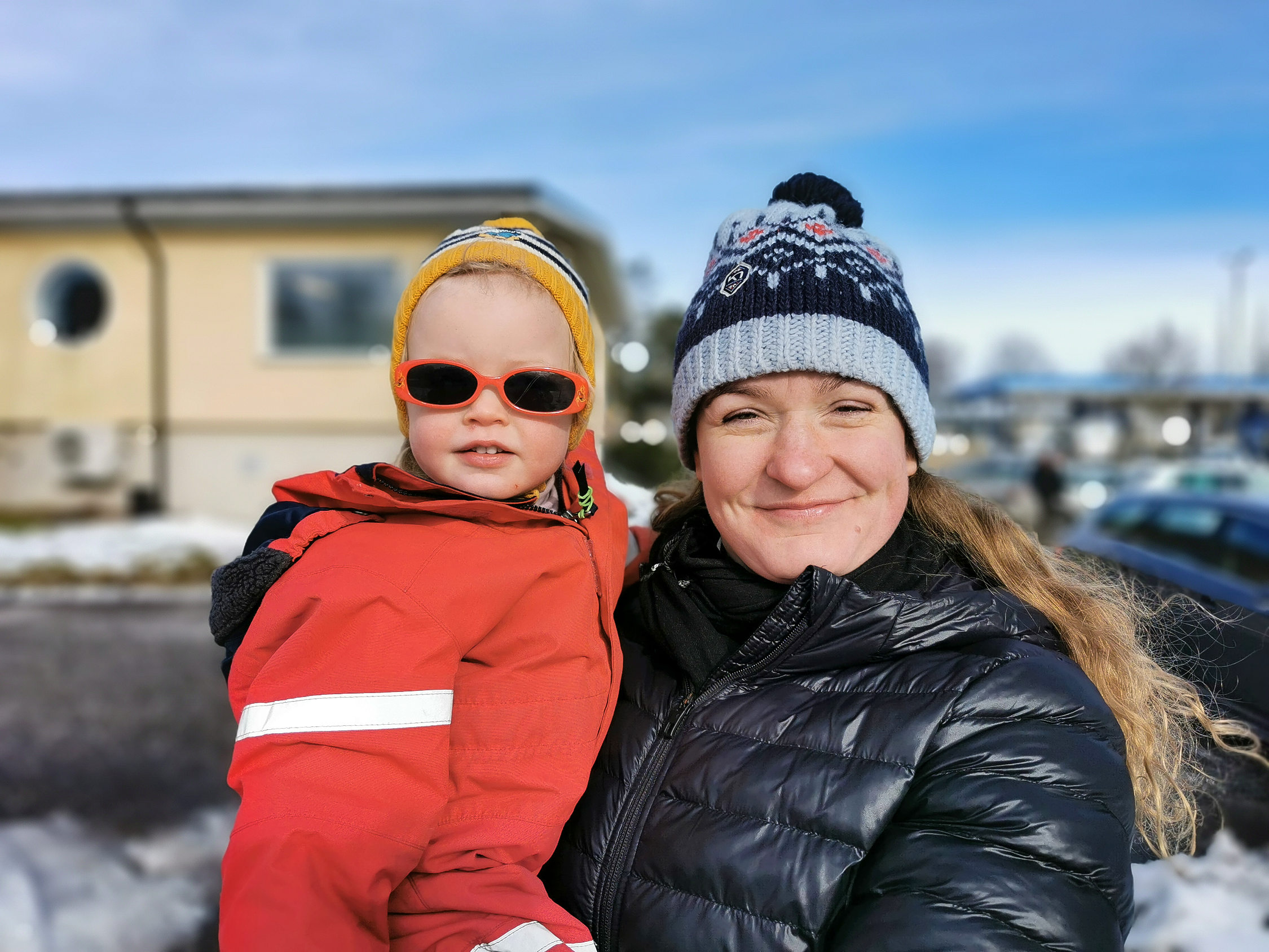 kvinnar med barn i famnen utomhus på vintern