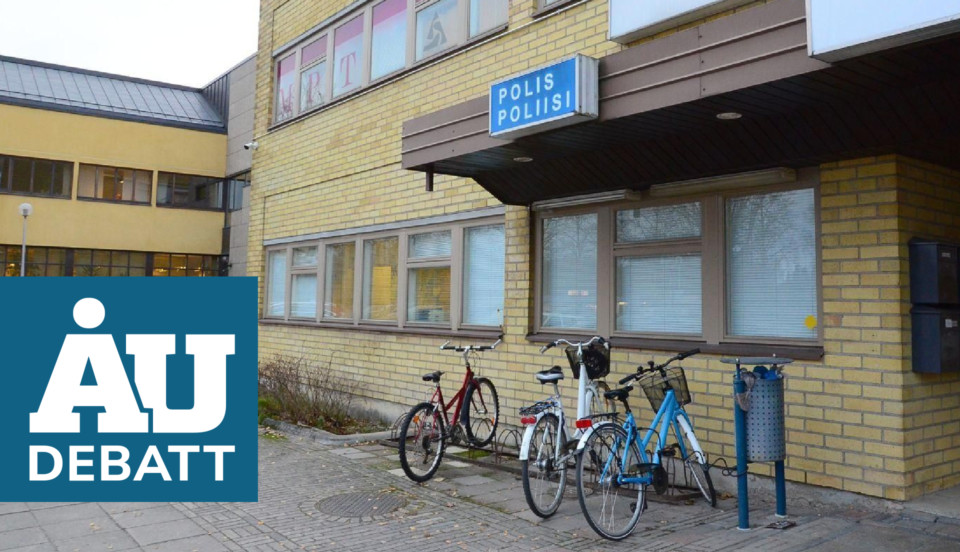 debattvinjett nere till vänster, polisstation i gult tegel bakom med cyklar framför