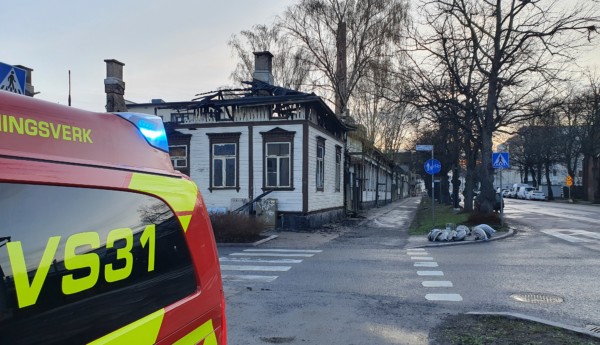 En brandbil och ett nedbrunnet hus.