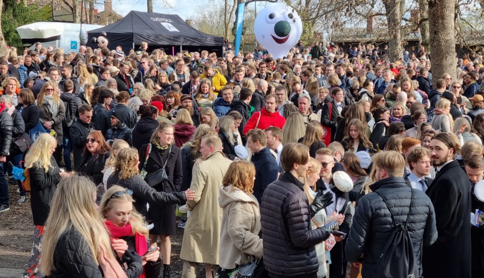 massor med vårklädda människor i en park