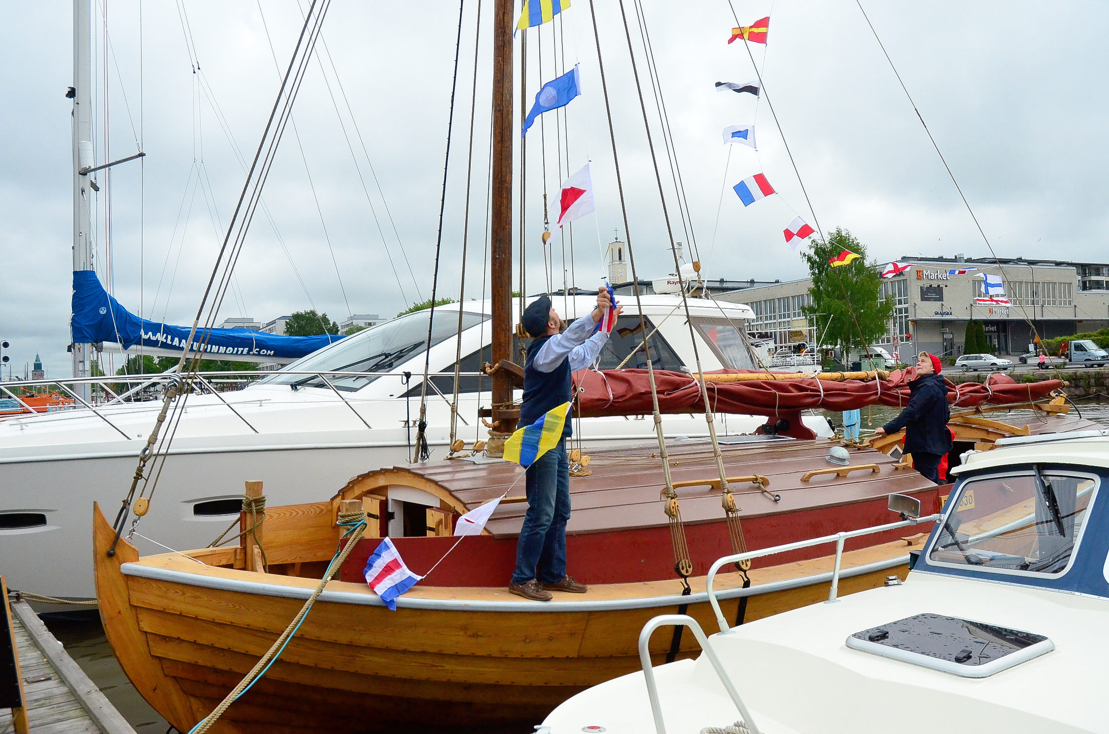 Stor segelbåt i trä, förtöjd i en hamn