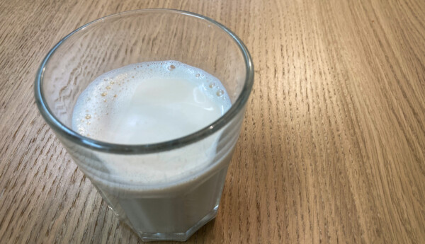 Ett glas fyllt med vit och aningen skummande dryck