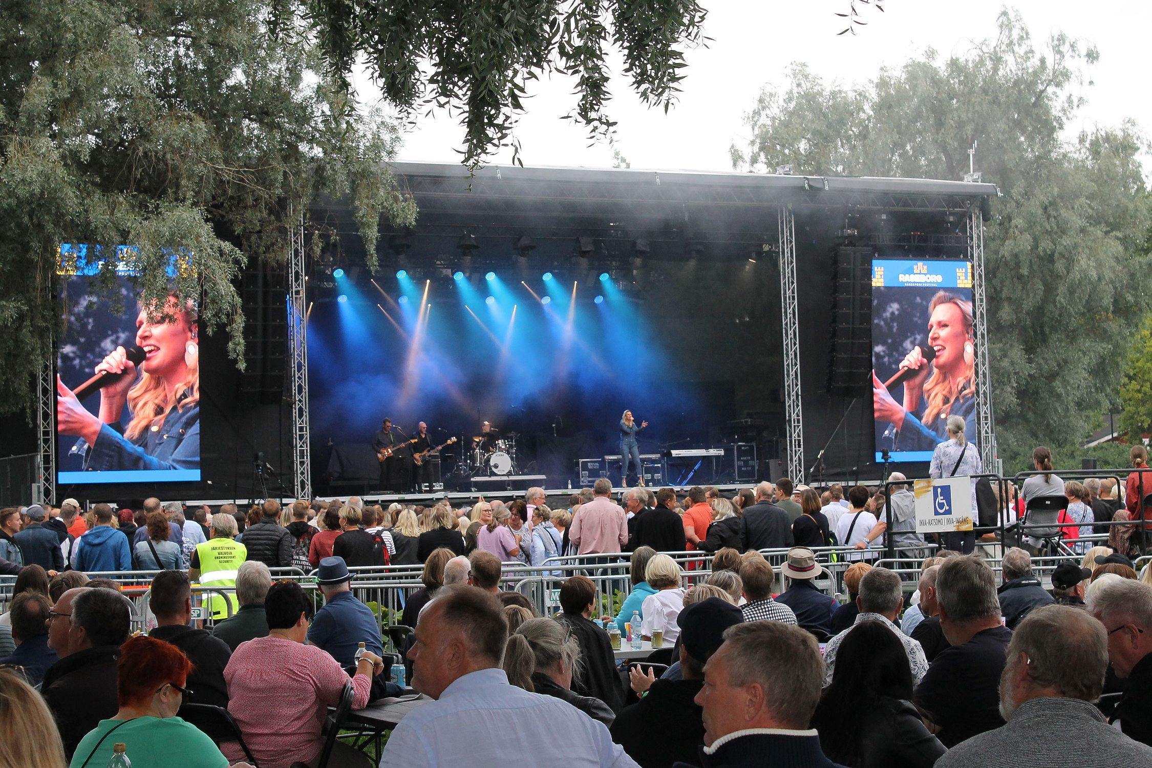 Sanna Nielsen står på scenen i Stallörs parken i Ekenäs. Framför scenen är många människor.