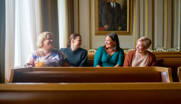 fyra leende kvinnor vid ett porträtt av en stadsdirektör