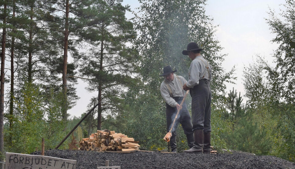 Kolargubbar i tidsenlig klädsel tänder kolmila.