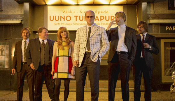 fem män och en kvinna uppställda framför en biograf