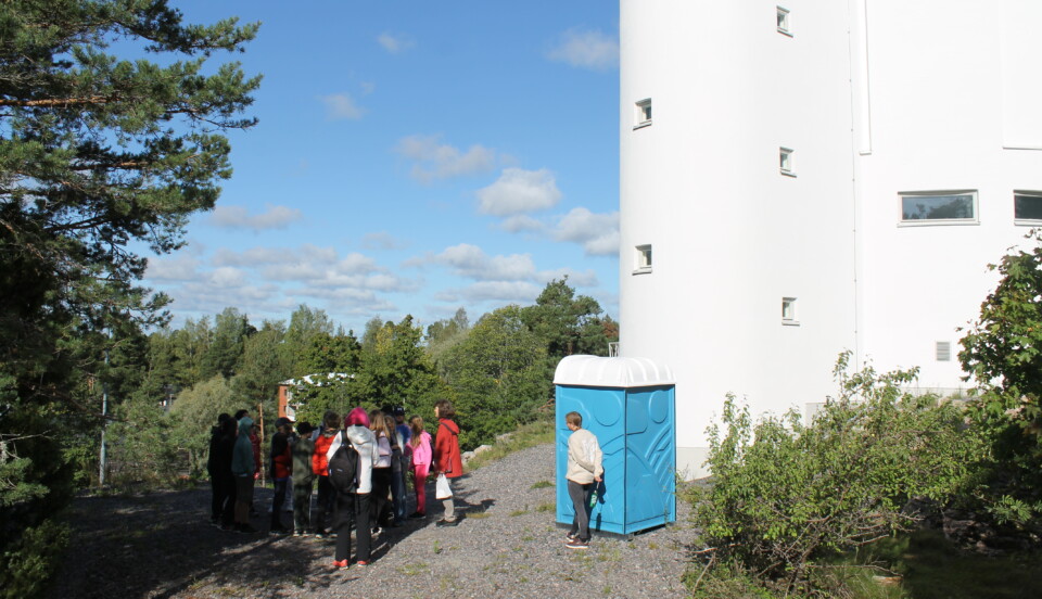 Fotat på håll en grupp elever utanför vattentornet i Karis. Där en kvinna berättar om stjärnor och planeter för eleverna.