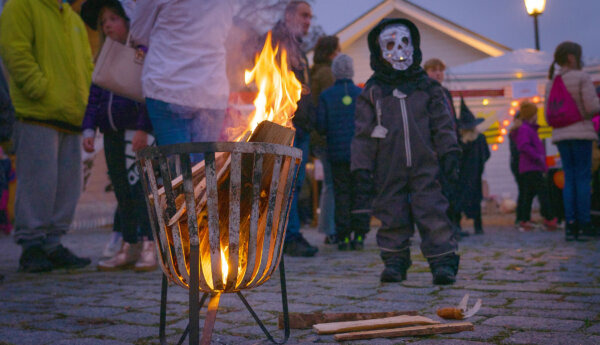 Maskerad pojke vid fackla.