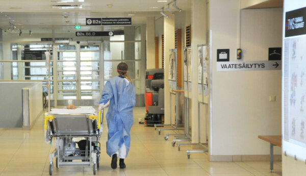 sjukvårdspersonal flyttar en patient i en säng